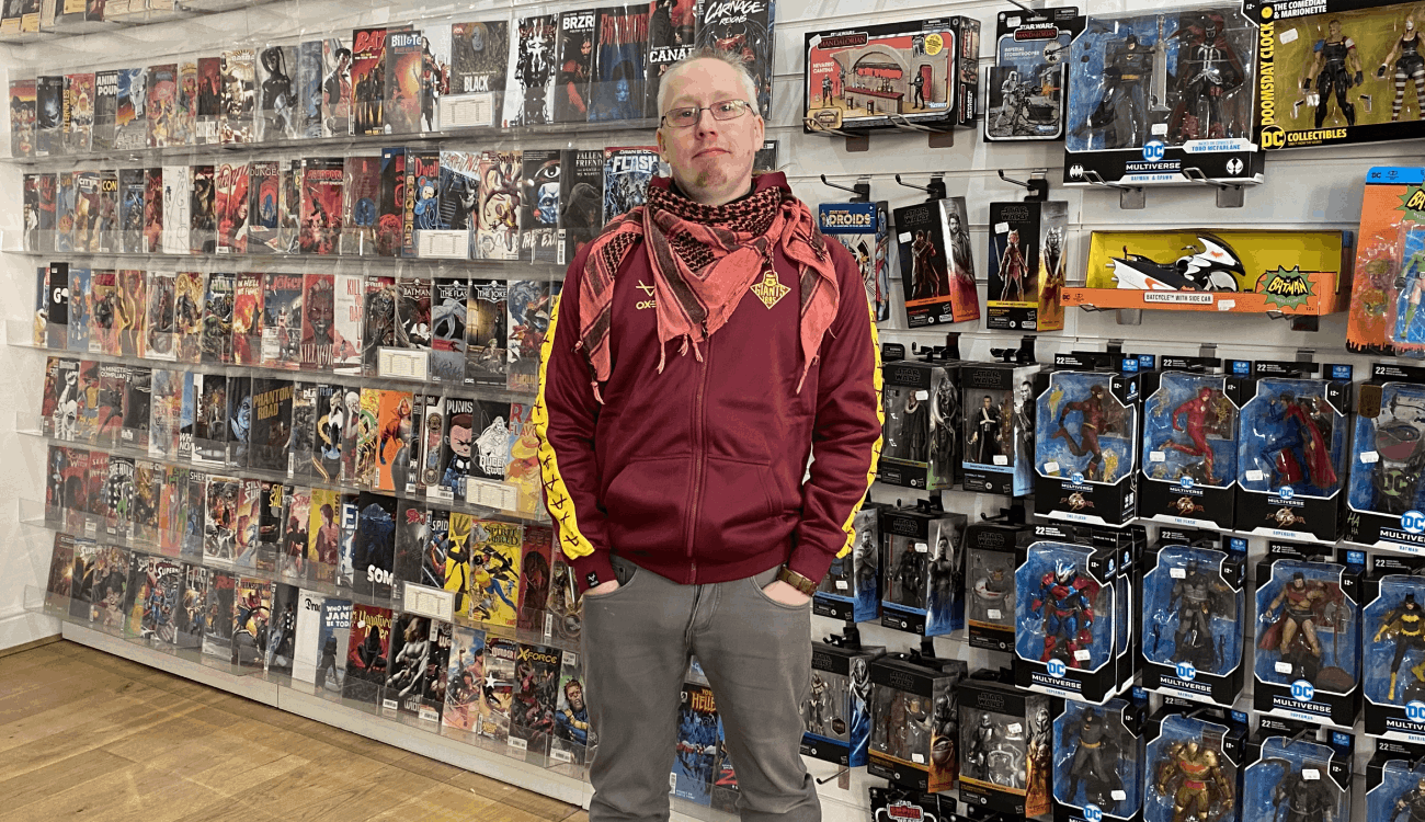 Man standing in a store. Behind the man you can see retro toys and magazines.
