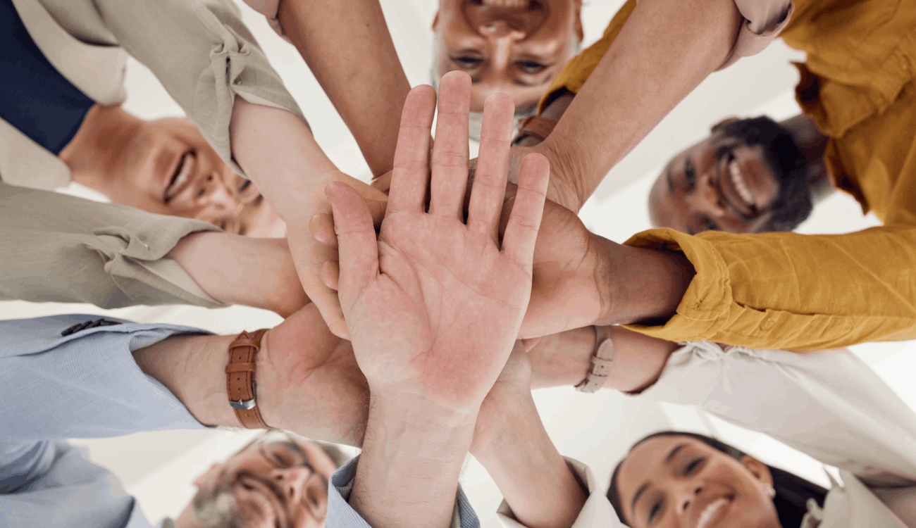 Group of people doing a team high five.