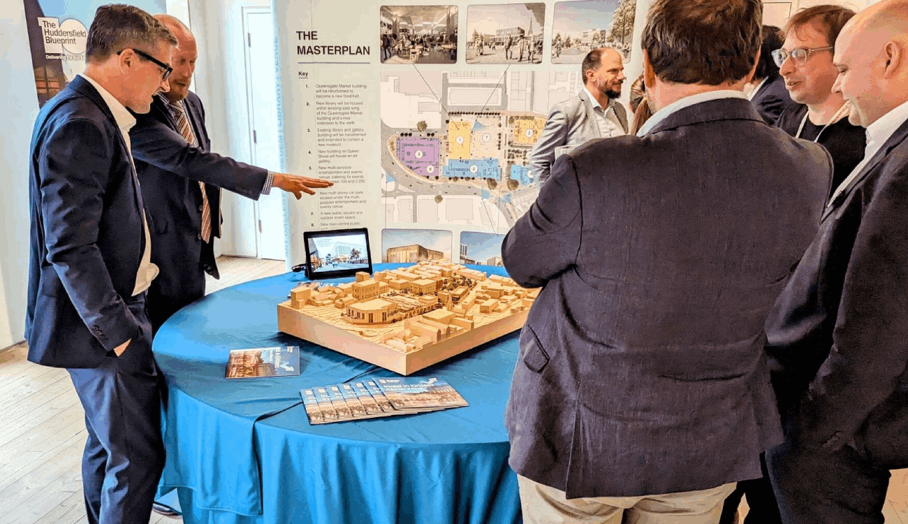 Group of people stood around a table discussing their plans.