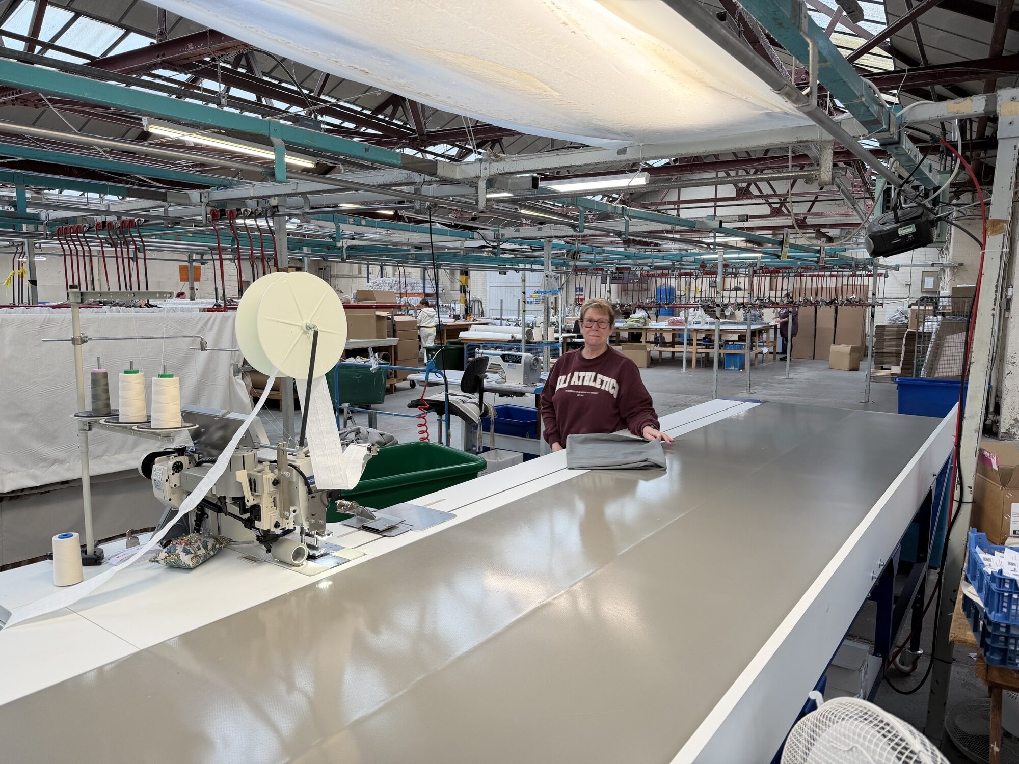 Image shows female employee stood by new machinery equipment at Gordon Johns.